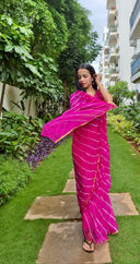 Pink chiffon leheriya saree with gold border, model posing outdoors Closeup 