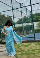 aqua green chiffon saree with white leaf print, model posing outdoors