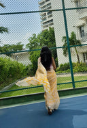 Sea green chiffon saree with white leaf print, model walking away outdoors