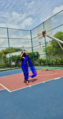 Blue chiffon leheriya saree with gold border, model shot from far