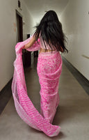 pink chiffon saree with white leaf print, model walking outdoors walking away