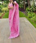 pink chiffon saree with white leaf print, model walking outdoors saree shot