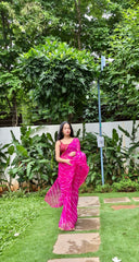 Pink chiffon leheriya saree with gold border, model standing outdoors
