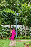 Pink chiffon leheriya saree with gold border, model walking outdoors