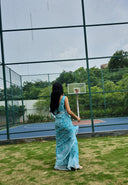 aqua green chiffon saree with white leaf print, model  posing back