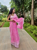 pink chiffon saree with white leaf print, model walking outdoors