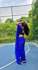 Blue chiffon leheriya saree with gold border, model in outdoors