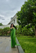 Green chiffon leheriya saree with gold border, model posing outdoors Side ways