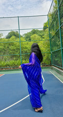 Blue chiffon leheriya saree with gold border, model close up shot