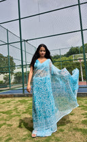 aqua green chiffon saree with white leaf print, model walking outdoors front profile